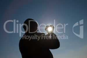 man holding a sun in his hands against the sky