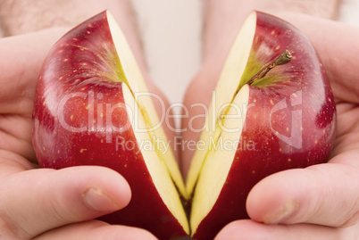 half an apple in  hands isolated on white