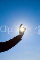 man holding a sun in his hands against the sky