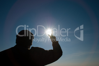 man holding a sun in his hands against the sky