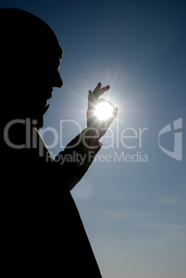 man holding a sun in his hands against the sky