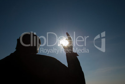 man holding a sun in his hands against the sky