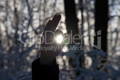 man holding a sun in his hands against the sky