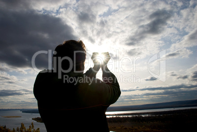 man holding a sun in his hands against the sky