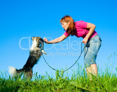 woman with her dog on meadow