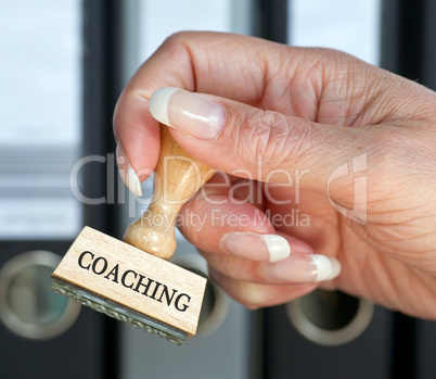 Coaching - Stempel mit Hand im Büro