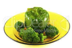 pepper and broccoli on a plate isolated on white