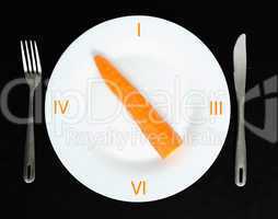 Carrot in a white plate on black background