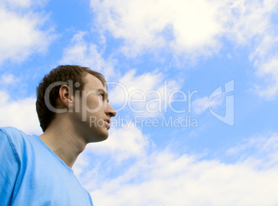 The young man looks at the blue sky