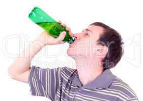 The young man drinks from a green bottle