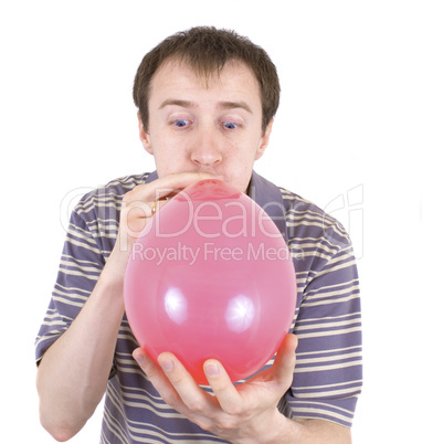 The young man inflates a red balloon