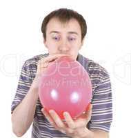 The young man inflates a red balloon
