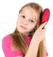 The beautiful girl brushes hair with a hairbrush