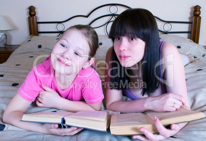 Mother and daughter reading in bed book