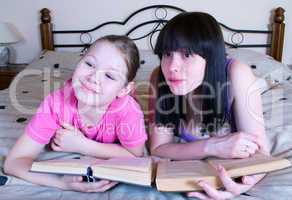 Mother and daughter reading in bed book