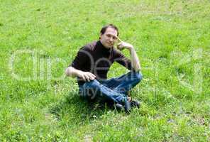 man sitting on green grass