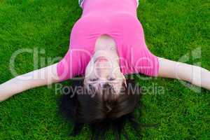 Young the woman lies on a green grass