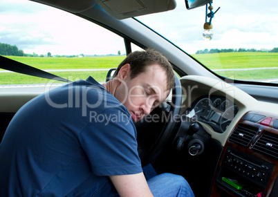 Young man sleeps in car