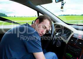 Young man sleeps in car