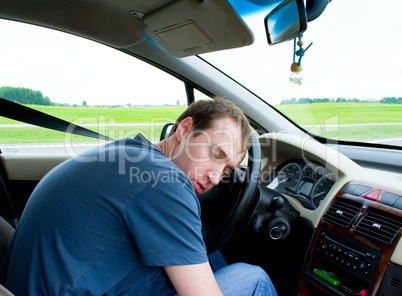 The man sleeps in the car