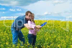 The father learns a daughter to launch frisbee on a meadow