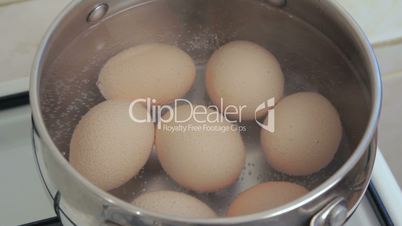 Eggs boiling in grey metall pan