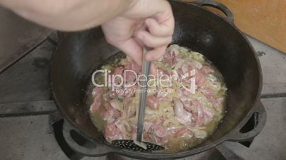 EDIT Turning with slotted spoon slices of pork and onions