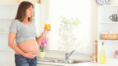 Schwangere Frau trinkt Orangensaft