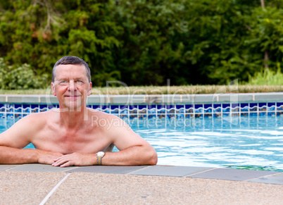 Senior man by edge of swimming pool