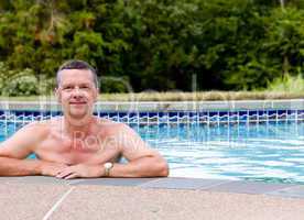 Senior man by edge of swimming pool