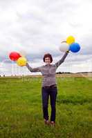 Frau mit Luftballons auf der Wiese freut sich 567
