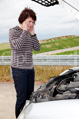 Frau vor geoeffneter Motorhaube 654