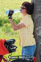 Durstige Radlerin trinkt aus der Wasserflasche 668