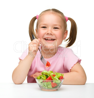 Cute little girl eats vegetable salad