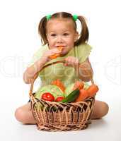 Cute little girl eats carrot