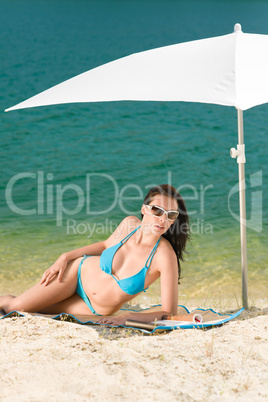 Summer beach woman blue bikini under parasol