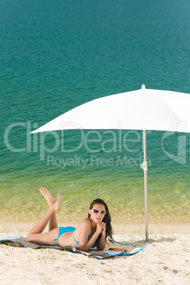 Summer beach woman blue bikini under parasol