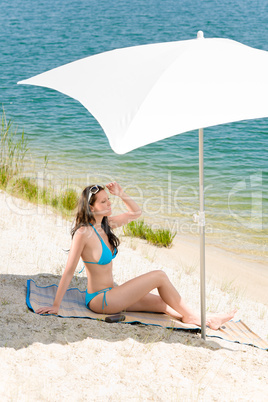 Summer beach woman blue bikini under parasol