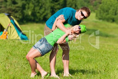 Young camping couple hugging in summer countryside