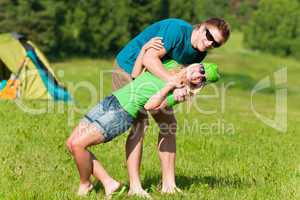 Young camping couple hugging in summer countryside