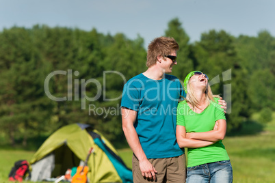 Young camping couple hugging in summer countryside