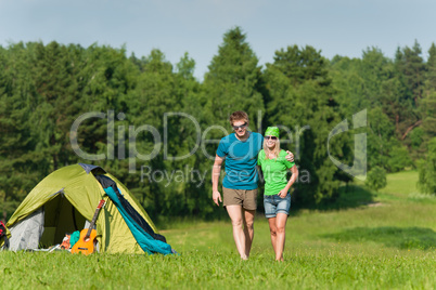 Young camping couple hugging in summer countryside