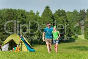 Young camping couple hugging in summer countryside