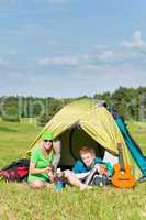 Young camping couple cooking meal outside tent