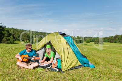 Camping couple play guitar summer in countryside