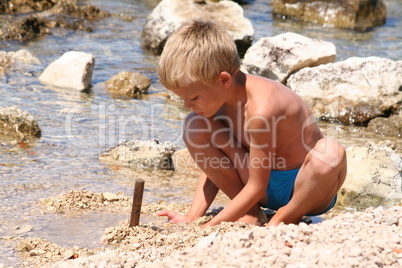 Ein Junge spielt am Strand