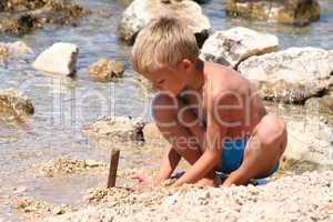 Ein Junge spielt am Strand