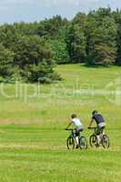 Sport mountain couple biking downhill sunny meadows