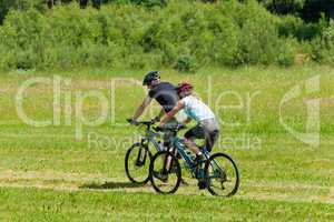 Sport mountain couple biking downhill sunny meadows