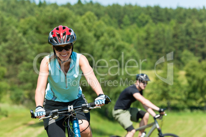 Sport mountain couple biking uphill sunny meadows